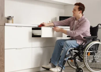 Investing in disability housing: A young man in a wheelchair using an accessible drawer